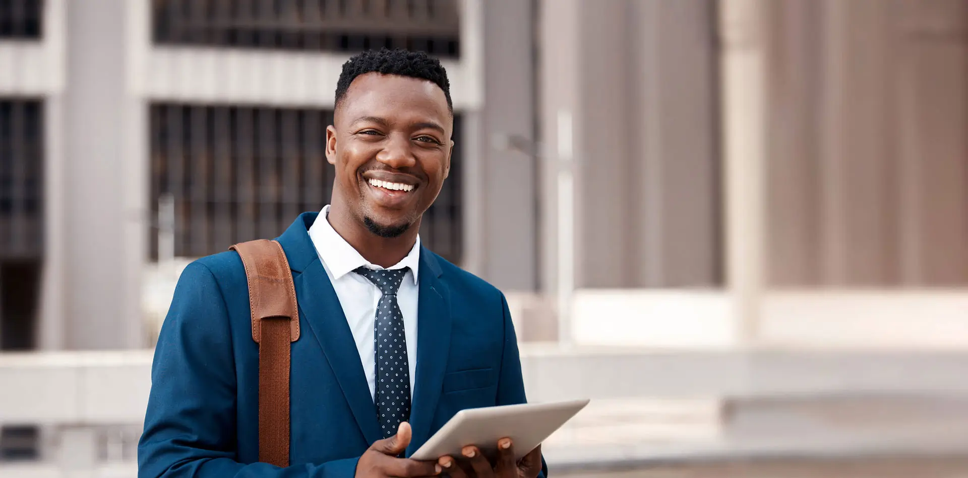 Regent University student smiling with a tablet in hand