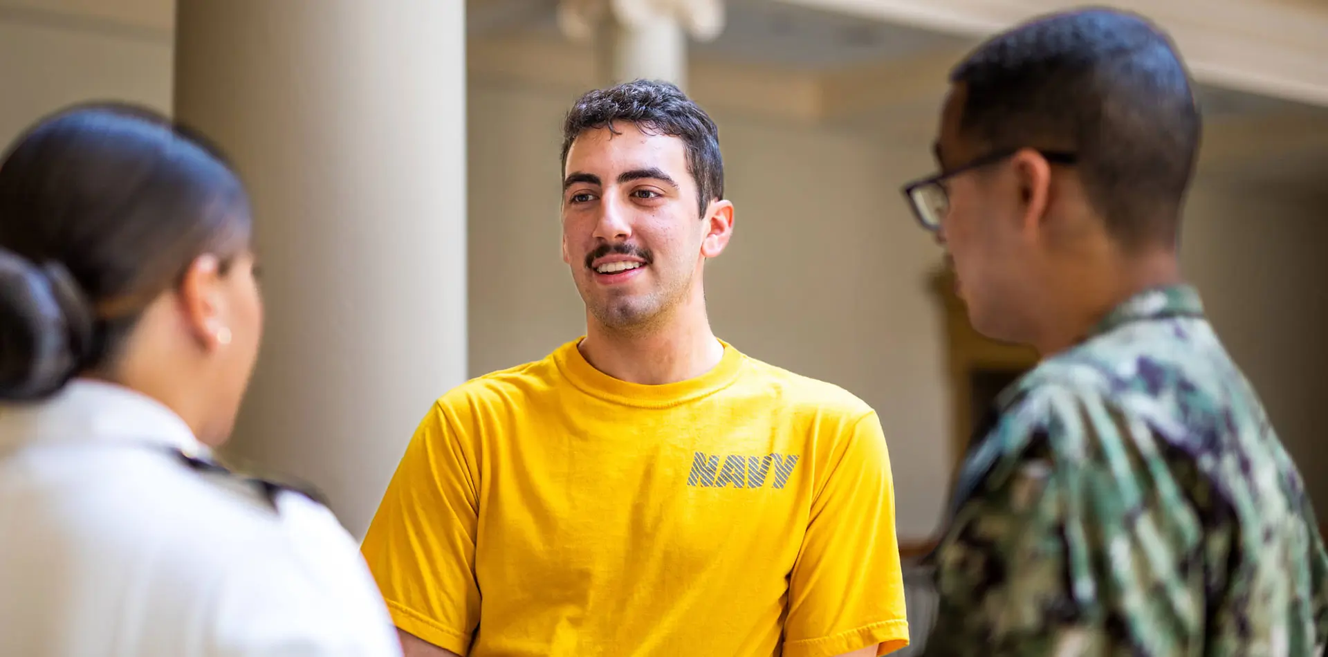 3 ROTC students talking in yellow t-shirt, BDU, and Class A