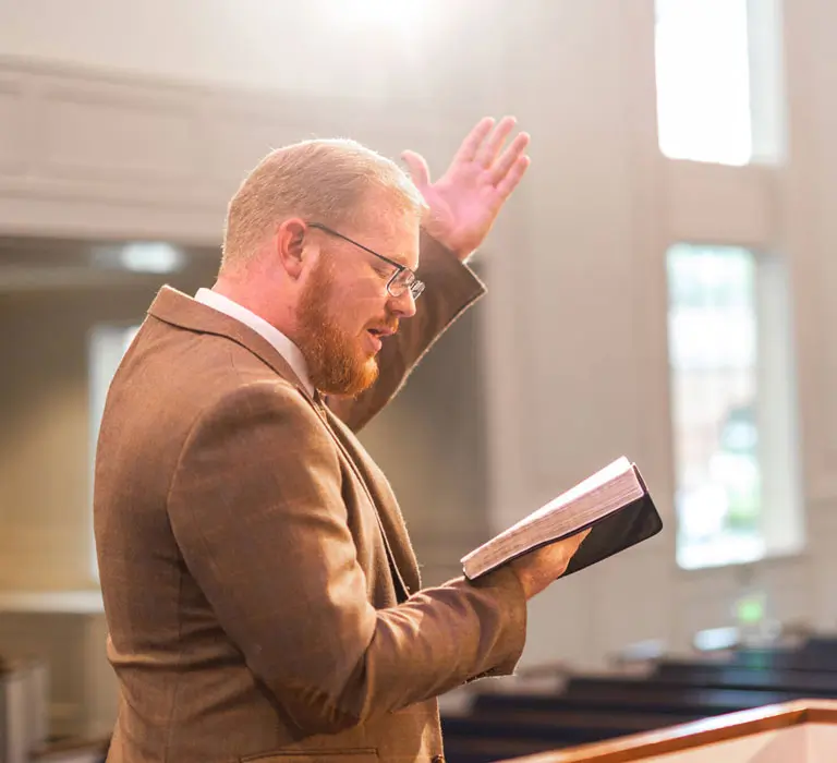 Man in chapel reading scripture